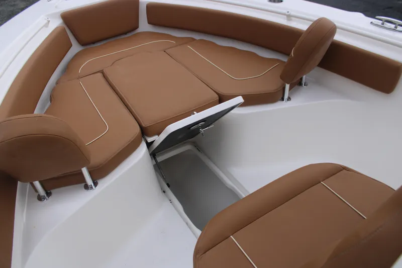 Slide: The Image of 2026 Key West 239 FS boat interior with brown cushioned seating and storage compartment. - 19
