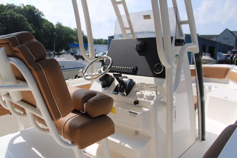 Slide: The Image of 2026 Key West 239 FS boat interior with steering wheel and brown seating. - 8