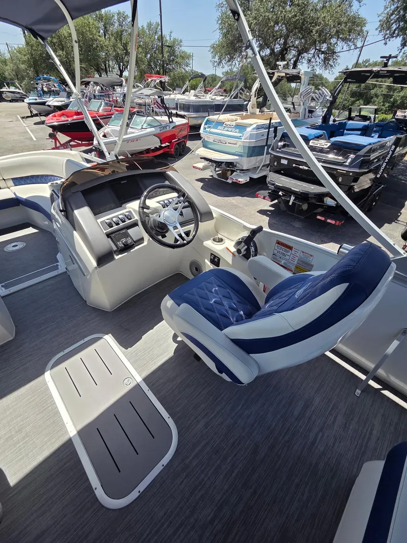 Slide: The Image of 2023 Bennington 25RTSB boat interior with steering console and blue seating. - 6