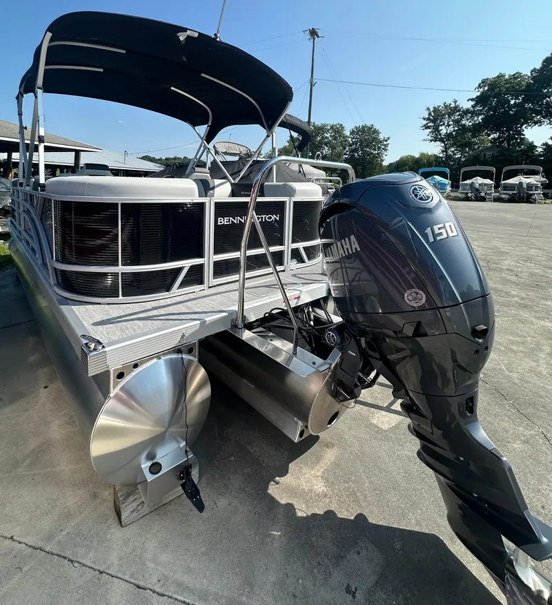 Slide: The Image of 2025 Bennington 22 SSRSE pontoon boat with Yamaha 150 outboard motor, parked outdoors. - 4