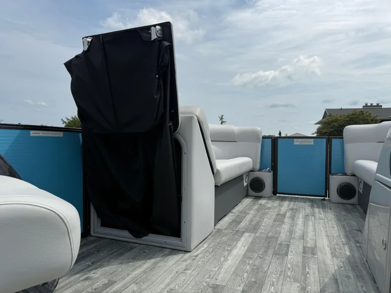 Slide: The Image of 2022 Crest 220 boat interior with gray seating and wood-style flooring under a cloudy sky. - 13