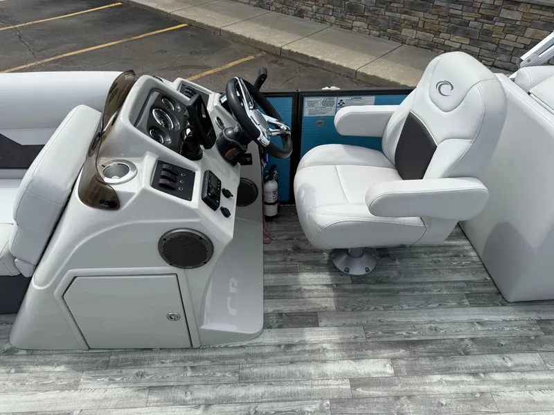 Slide: The Image of Captain's seat and console of a 2022 Crest 220 boat, featuring modern controls and seating. - 16