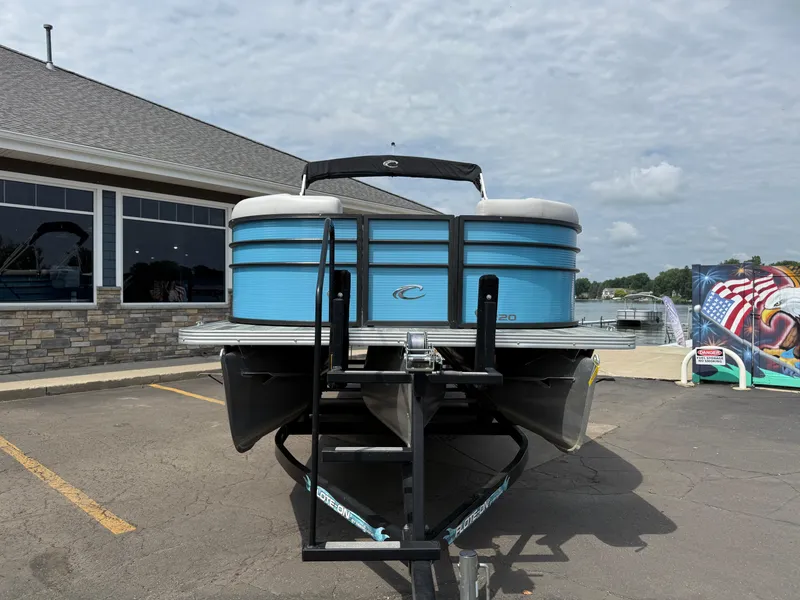 Slide: The Image of 2022 Crest 220 pontoon boat on trailer, parked outside a building. - 4