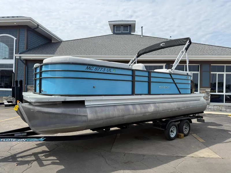Slide: The Image of 2022 Crest 220 pontoon boat on trailer, parked outside a building. - 5