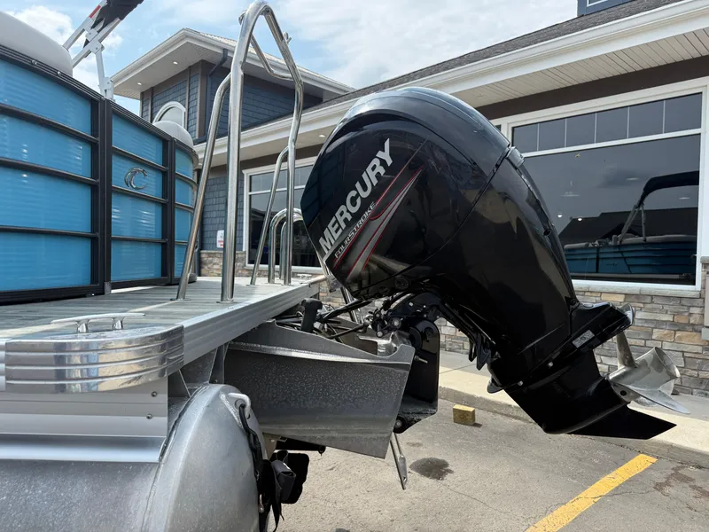 Slide: The Image of 2022 Crest 220 pontoon boat with Mercury outboard motor, parked near a building. - 6