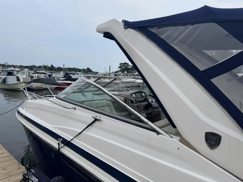 Slide: The Image of 2018 Regal 28 Express boat docked at marina, featuring sleek design and blue canopy. - 2