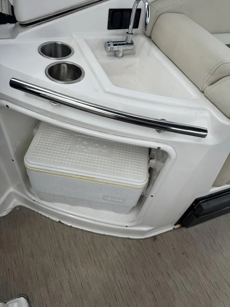 Slide: The Image of 2018 Regal 28 Express boat interior with sink, cup holders, and Igloo cooler storage. - 5