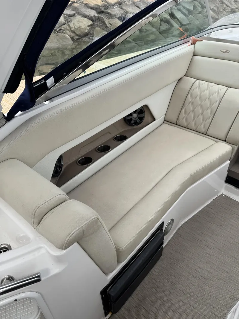 Slide: The Image of 2018 Regal 28 Express boat interior with beige seating and cup holders. - 6
