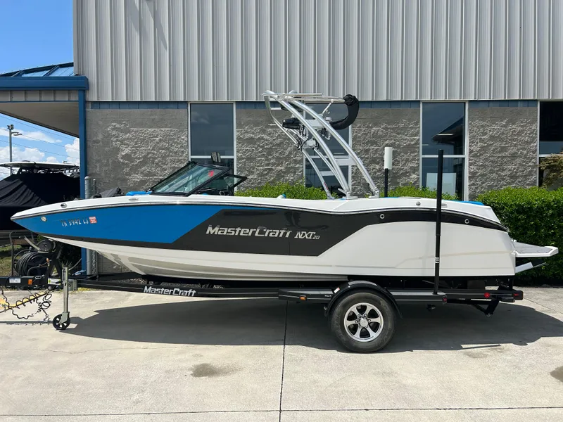 Slide: The Image of 2017 MasterCraft NXT20 boat on trailer, parked outside a building. - 1