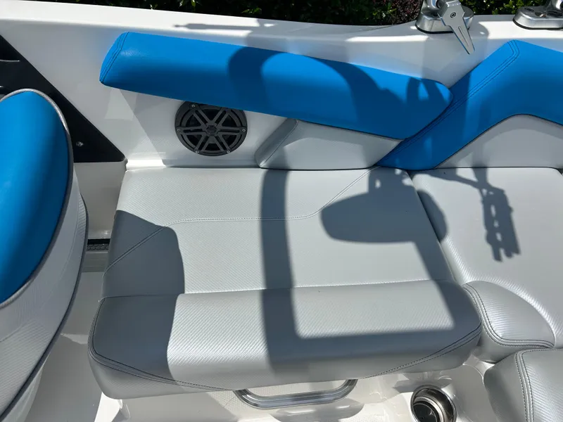 Slide: The Image of 2017 MasterCraft NXT20 boat interior with blue and gray seating, speaker, and cup holder. - 12