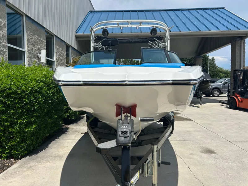 Slide: The Image of 2017 MasterCraft NXT20 boat on trailer, parked outdoors near a building. - 2
