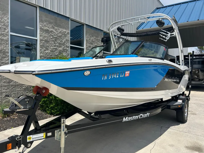 Slide: The Image of 2017 MasterCraft NXT20 boat on trailer, blue and white exterior, parked outside a building. - 4