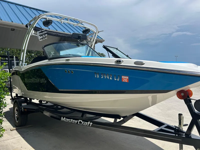 Slide: The Image of 2017 MasterCraft NXT20 boat on trailer, blue and white design, parked outdoors. - 5