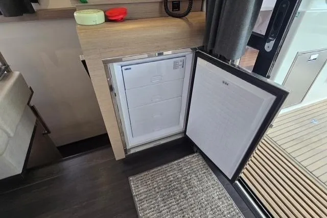 Slide: The Image of Interior view of 2022 Fountaine Pajot Tanna 47 yacht with open refrigerator. - 15