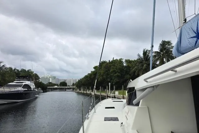 Slide: The Image of 2022 Fountaine Pajot Tanna 47 catamaran docked in a serene marina setting. - 8