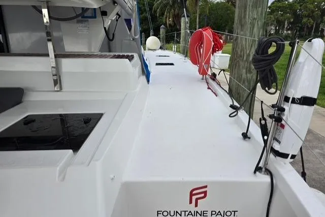 Slide: The Image of 2022 Fountaine Pajot Tanna 47 catamaran deck with safety equipment and sleek design. - 9