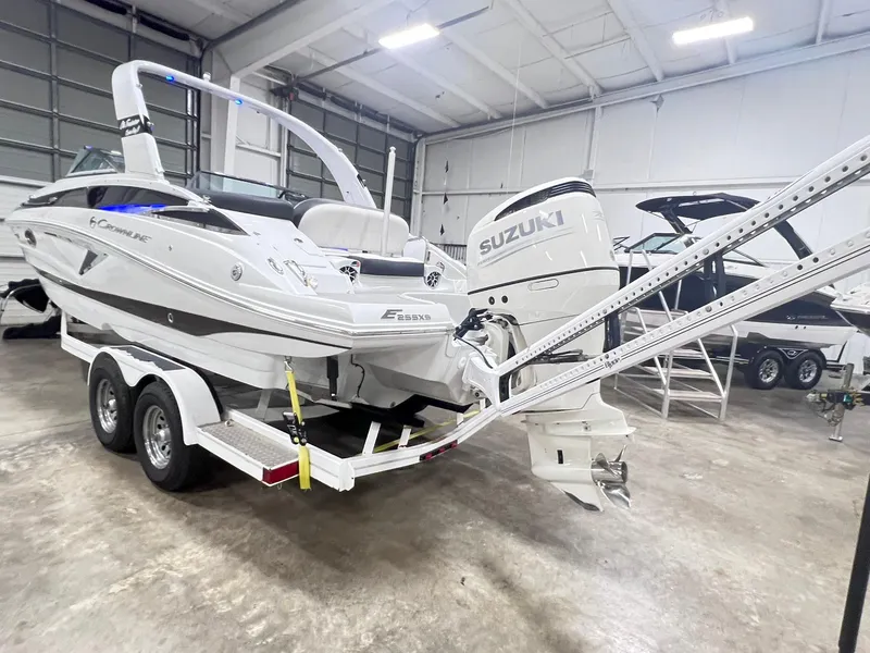 Slide: The Image of 2020 Crownline Eclipse E225 XS boat with Suzuki outboard motor on trailer in showroom. - 1