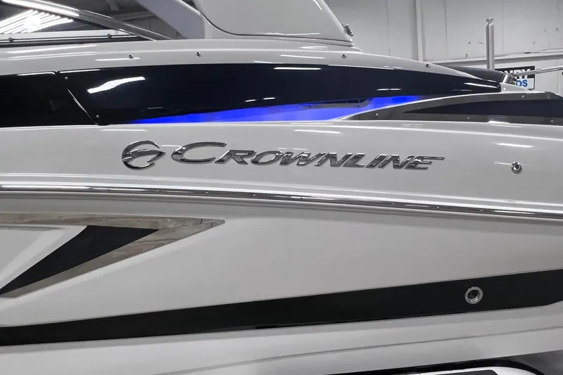 Slide: The Image of 2020 Crownline E225 XS boat side view with logo and sleek design. - 10