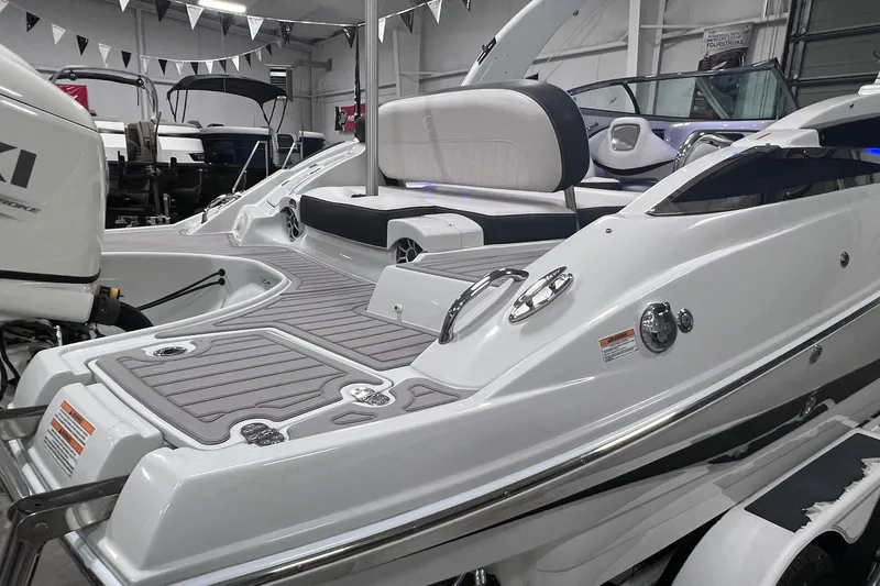 Slide: The Image of 2020 Crownline E225 XS boat interior with seating and deck details in showroom. - 44