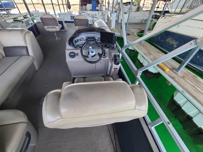 Slide: The Image of Interior of a 2021 Sun Tracker 22 Fishin Barge with steering console and seating. - 10