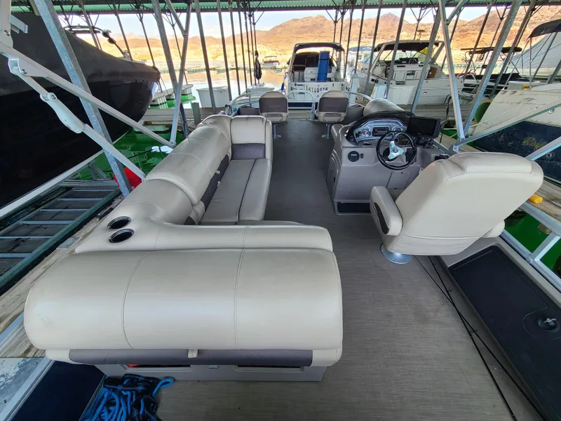 Slide: The Image of 2021 Sun Tracker 22 Fishin Barge interior with beige seating and steering console. - 14