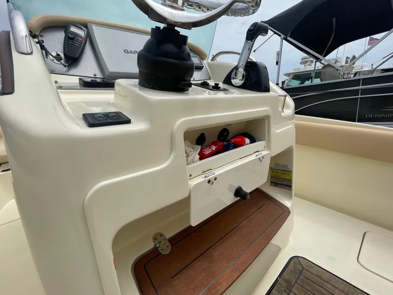 Slide: The Image of 2015 Chris-Craft Catalina 23 boat dashboard with storage compartment and navigation equipment. - 12