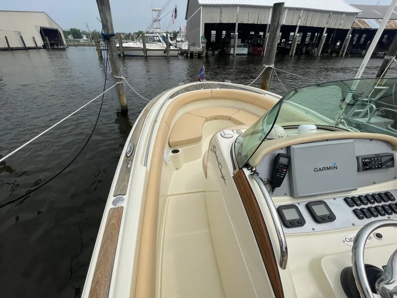 Slide: The Image of 2015 Chris-Craft Catalina 23 boat docked, featuring Garmin navigation system and spacious seating. - 15