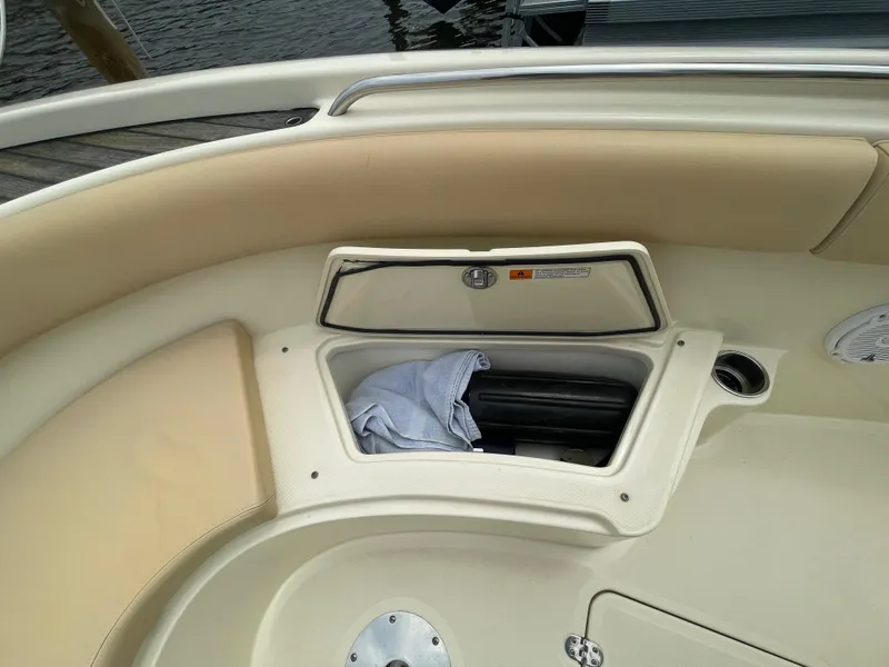 Slide: The Image of 2015 Chris-Craft Catalina 23 boat interior storage compartment with beige seating and open hatch. - 28