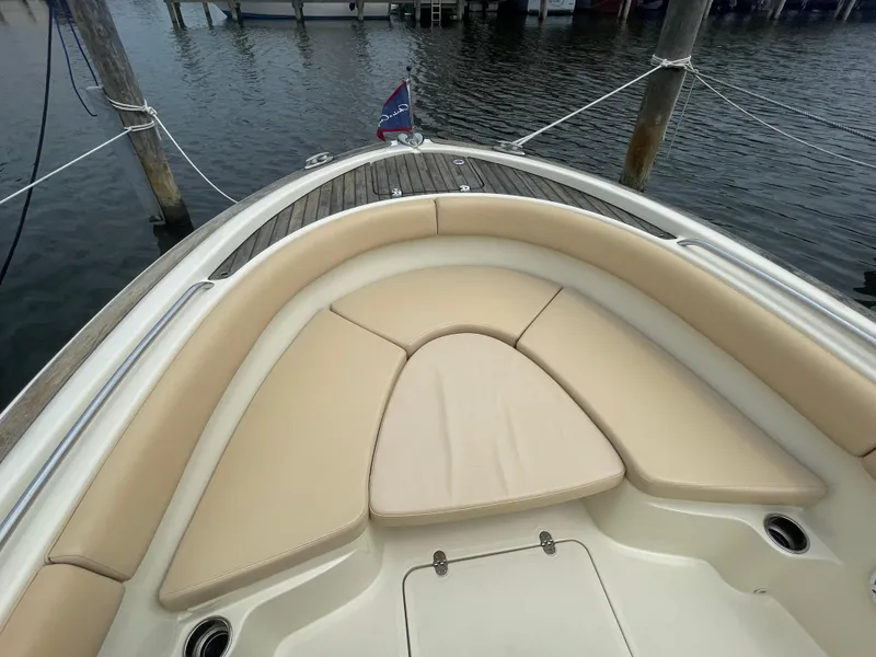 Slide: The Image of 2015 Chris-Craft Catalina 23 boat with beige seating, docked on calm water. - 32