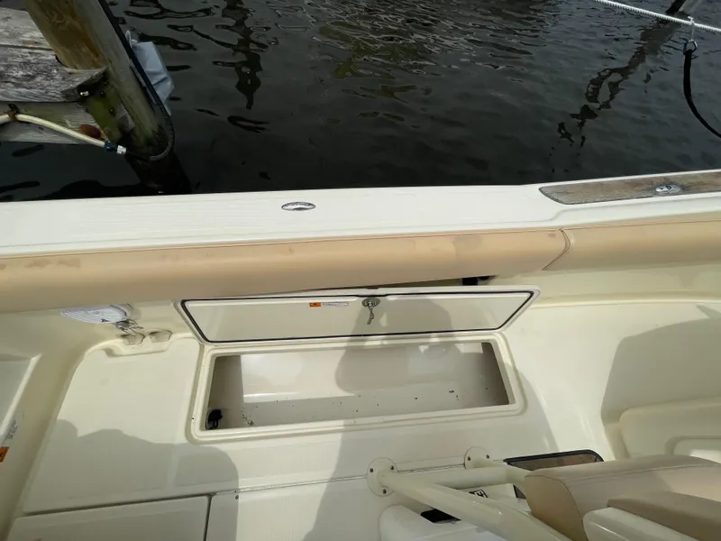 Slide: The Image of 2015 Chris-Craft Catalina 23 boat interior with storage compartment, docked by water. - 9
