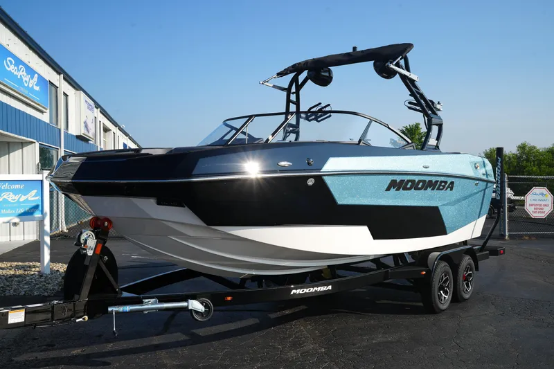 The Image of 2025 Moomba Max boat on trailer, parked outside dealership. - 1