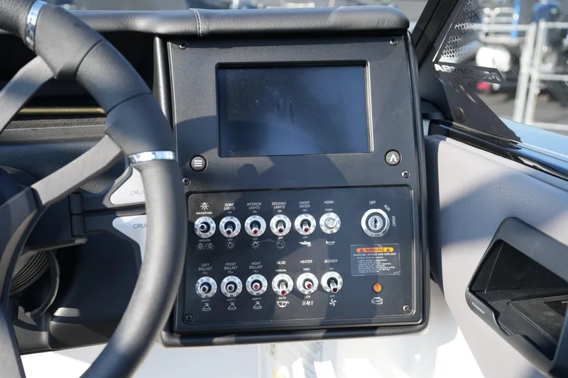 Slide: The Image of Control panel of a 2025 Moomba Max boat with steering wheel and display screen. - 10