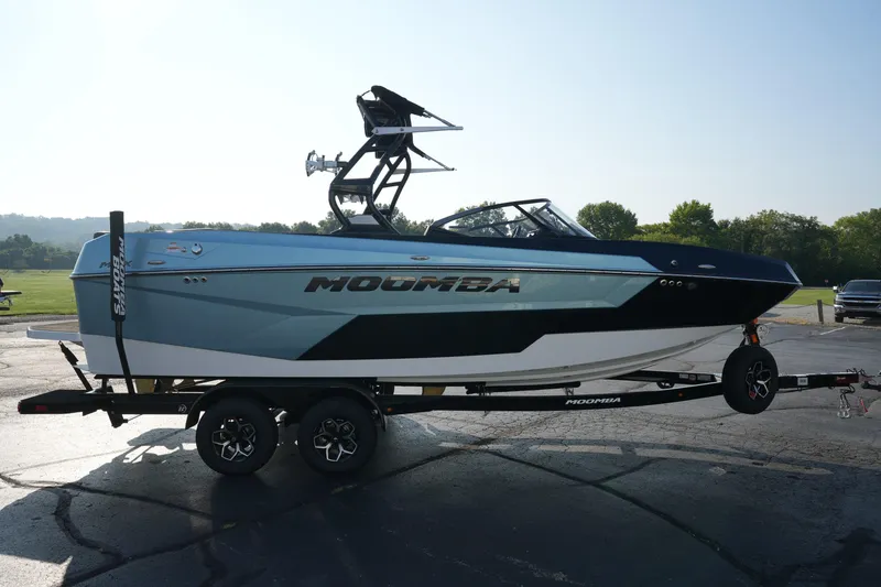 Slide: The Image of 2025 Moomba Max boat on trailer, parked outdoors, side view. - 3