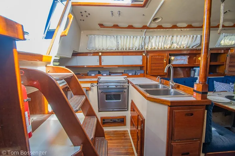 Slide: The Image of Interior of a 1987 Catalina 36 sailboat with wooden cabinetry and kitchen area. - 11