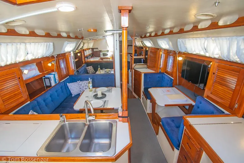Slide: The Image of Interior of 1987 Catalina 36 sailboat with blue seating and wooden cabinetry. - 14