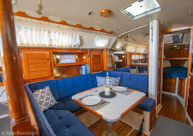Slide: The Image of Interior of a 1987 Catalina 36 sailboat with cozy dining area and blue upholstery. - 15