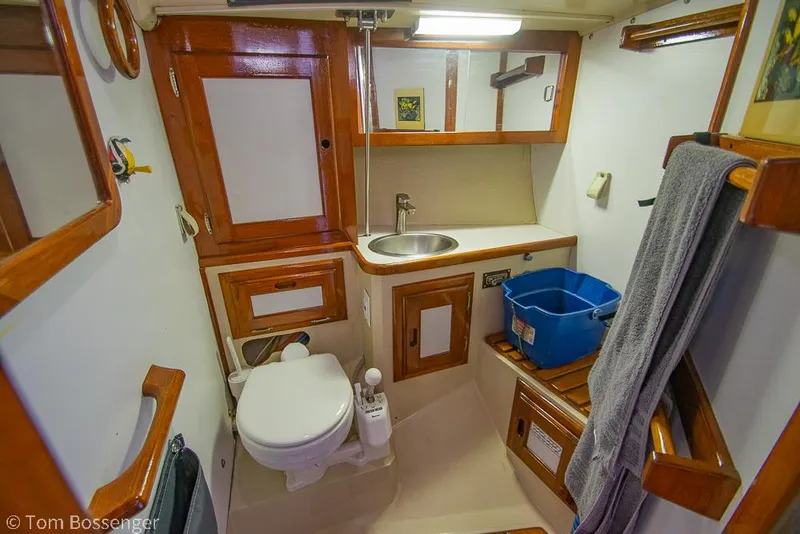 Slide: The Image of 1987 Catalina 36 yacht bathroom with wooden cabinetry, sink, and toilet. - 23