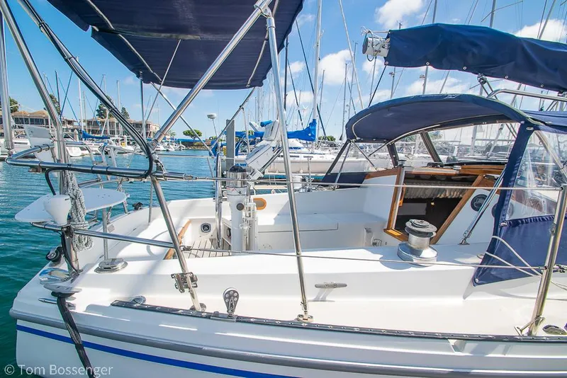 Slide: The Image of 1987 Catalina 36 sailboat docked in a marina, featuring a spacious cockpit and blue canopy. - 5