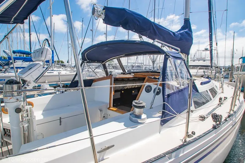 Slide: The Image of 1987 Catalina 36 sailboat docked in marina, featuring blue canvas covers and polished deck. - 6