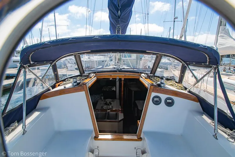 Slide: The Image of Cockpit view of a 1987 Catalina 36 sailboat with blue canopy and marina background. - 7