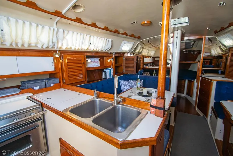 Slide: The Image of Interior of a 1987 Catalina 36 sailboat, featuring a cozy kitchen and dining area. - 9