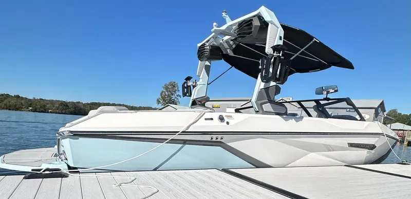 Slide: The Image of 2025 Nautique Super Air Nautique G23 boat docked on a sunny day, featuring sleek design and modern features. - 18
