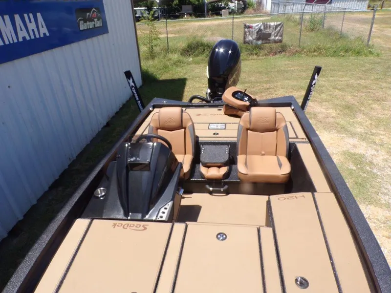 Slide: The Image of 2026 Xpress H20 Bass boat with tan seats and Yamaha engine, parked outdoors. - 13