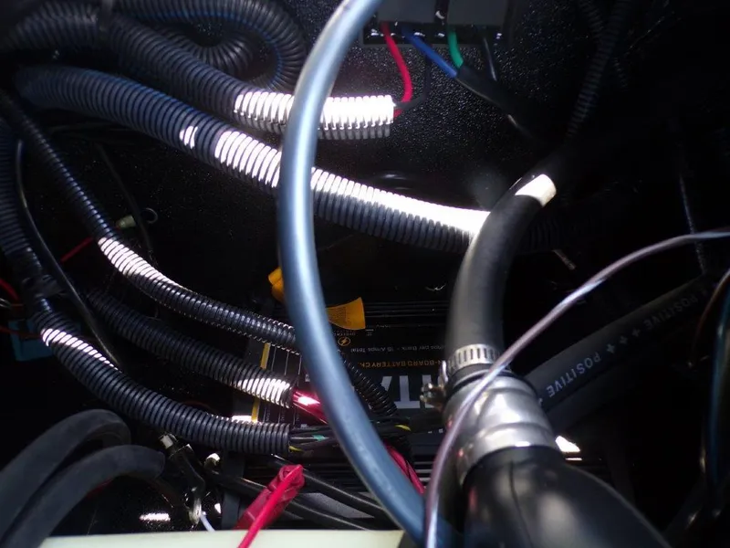 Slide: The Image of Tangled wires and cables inside a 2026 Xpress H20 Bass boat. - 19