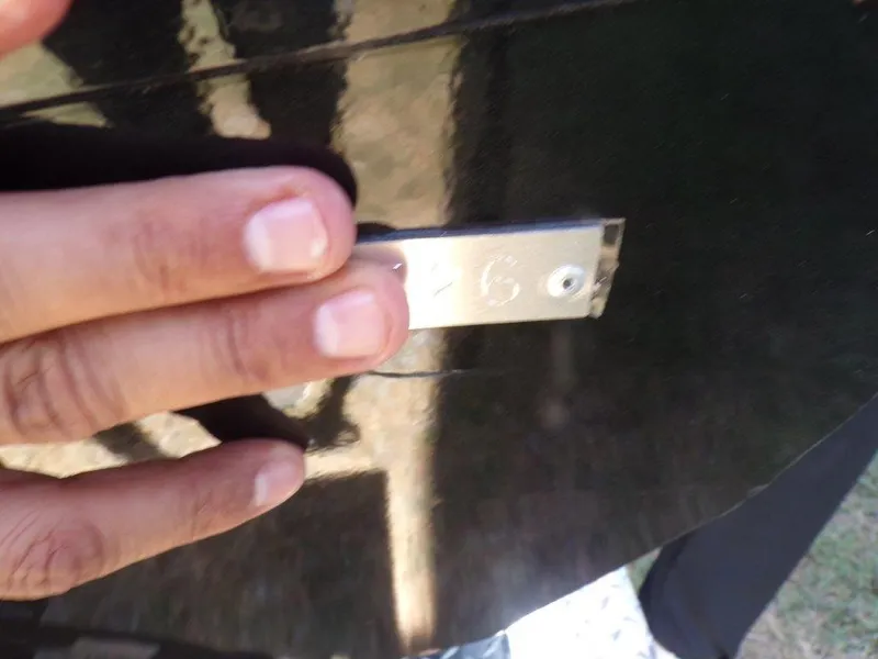 Slide: The Image of Close-up of a hand touching a metal plate on a 2026 Xpress H20 Bass boat. - 20