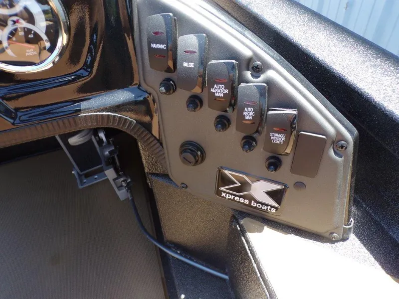 Slide: The Image of Control panel of 2026 Xpress H20 Bass boat with various switches and gauges. - 25