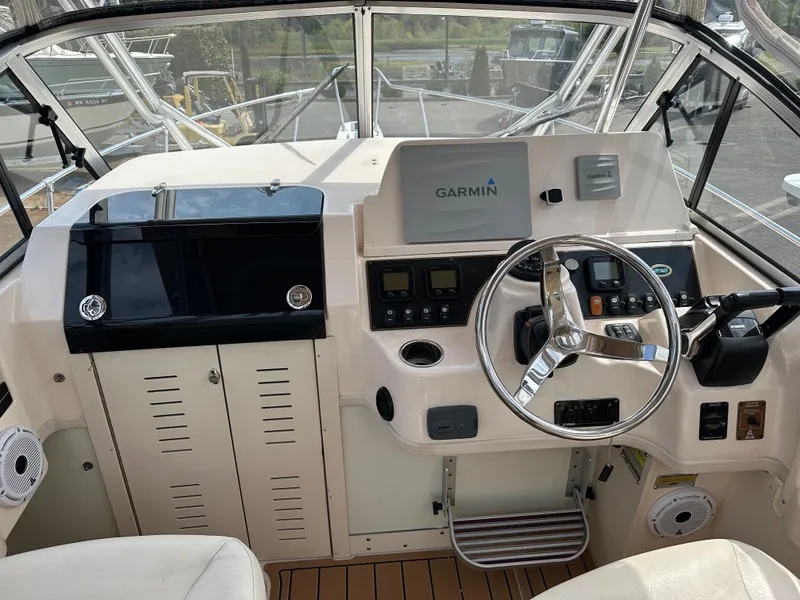 Slide: The Image of 2014 Grady-White 232 Gulfstream boat cockpit with Garmin navigation system and steering wheel. - 10