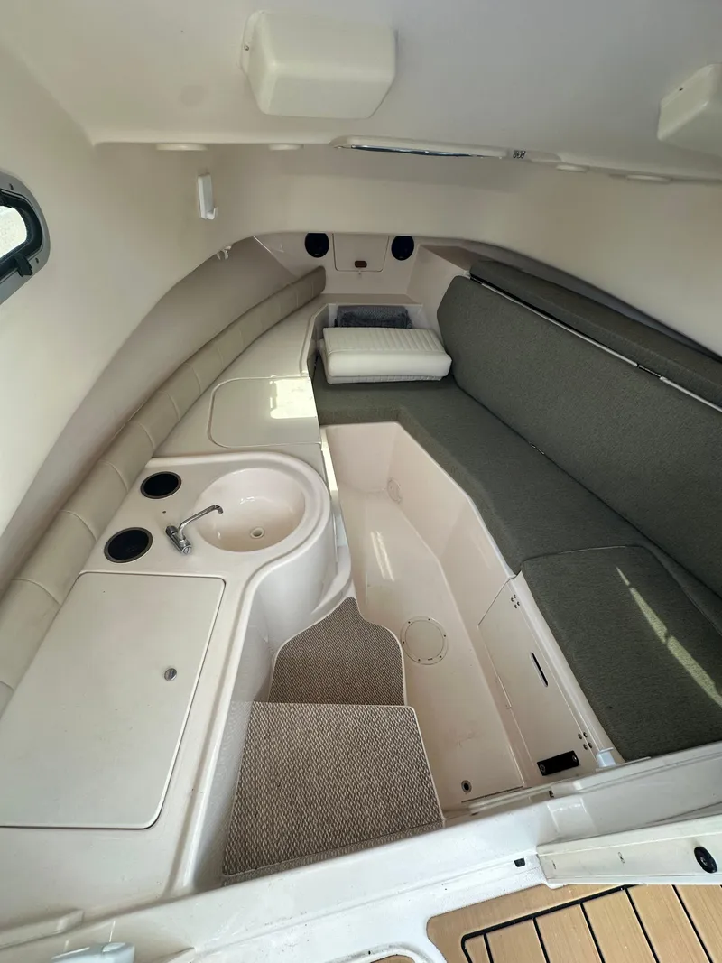 Slide: The Image of 2014 Grady-White 232 Gulfstream cabin interior with sink and seating area. - 14