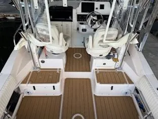Slide: The Image of 2014 Grady-White 232 Gulfstream boat interior with dual seats and wooden flooring. - 4