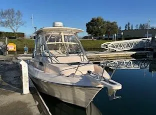 Slide: The Image of 2014 Grady-White 232 Gulfstream boat docked at a marina under clear blue skies. - 6